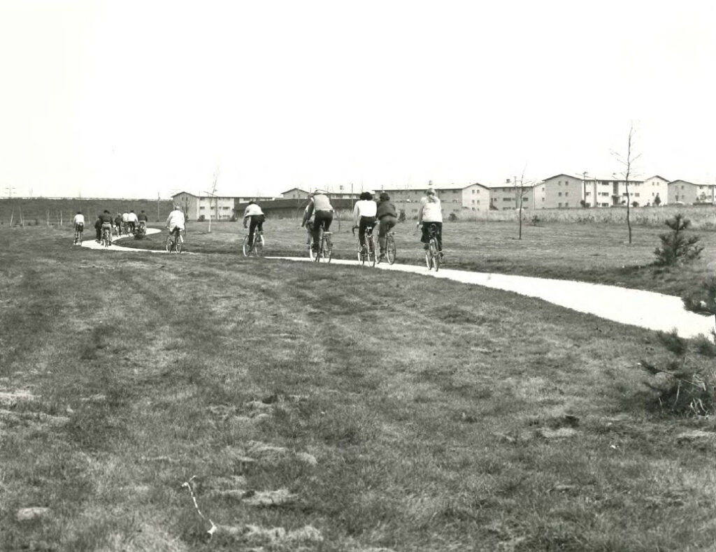 a 1977 photo of bikers on a freshly poured concrete bikeway in a field.